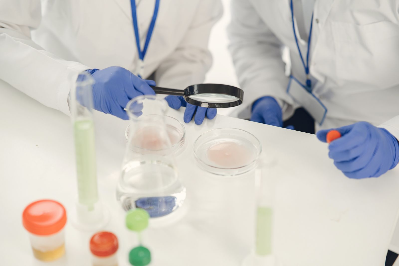 Des chercheurs en blouses de laboratoire examinant des échantillons et menant des expériences avec des tubes à essai et 
